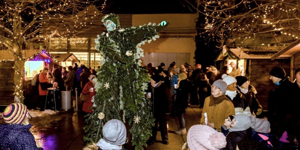 Festliche Pannonien Magazin Weihnachtsmarkt mit Lichterdekoration und Kindern.