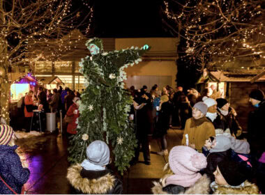 Festliche Pannonien Magazin Weihnachtsmarkt mit Lichterdekoration und Kindern.